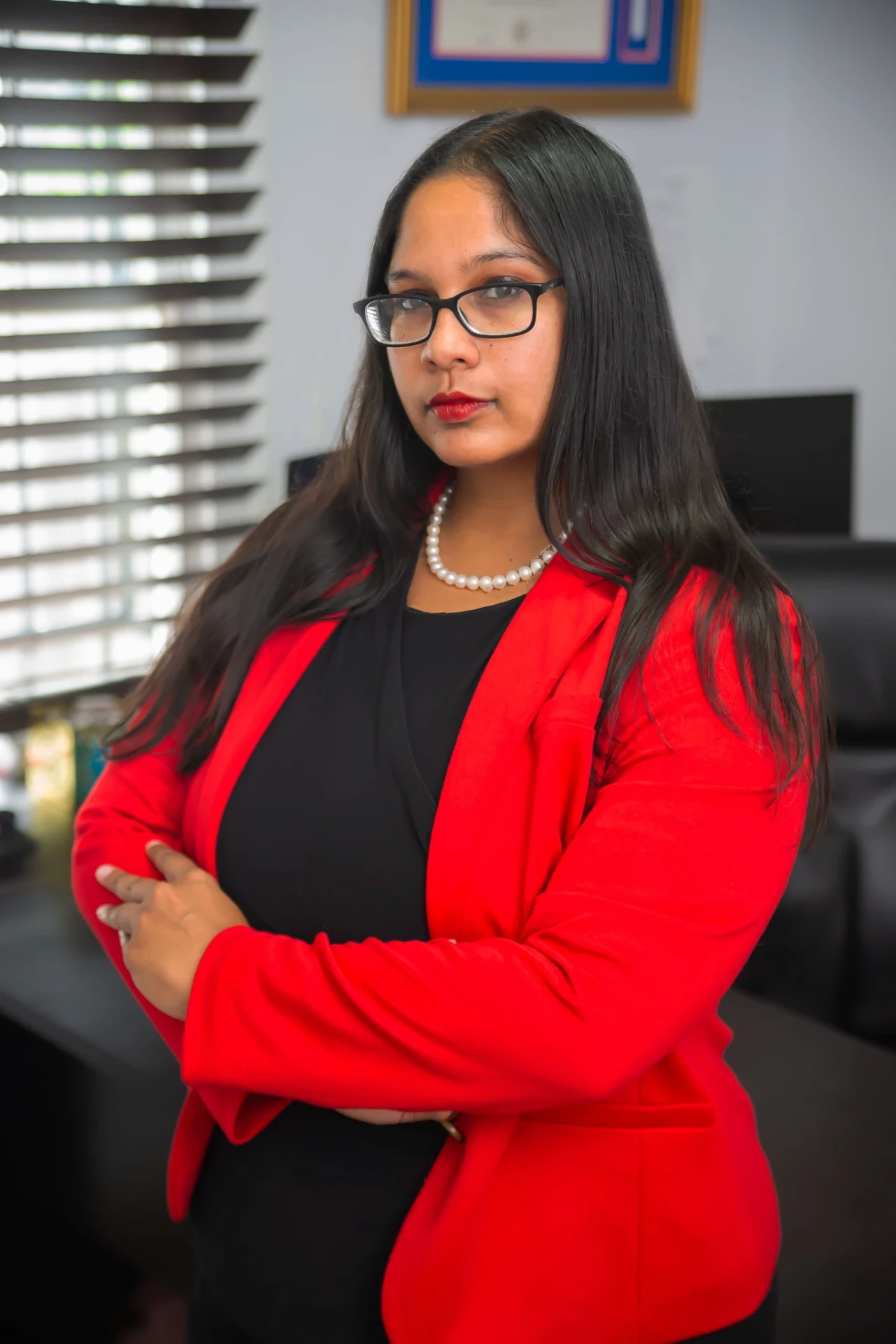 Sabrina Jadunandan in a red blazer — present-day portrait of The DUI Gyal.